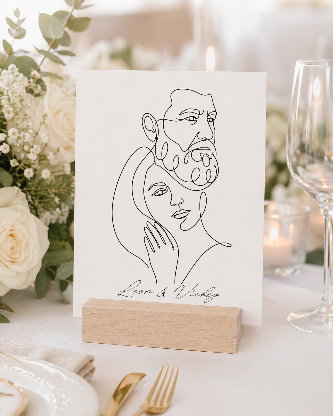Line art portrait of Leon & Vickey on a wooden stand at a wedding table